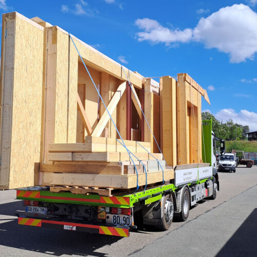 Chargement des éléments sur camion-plateau pour la construction de maison structure bois