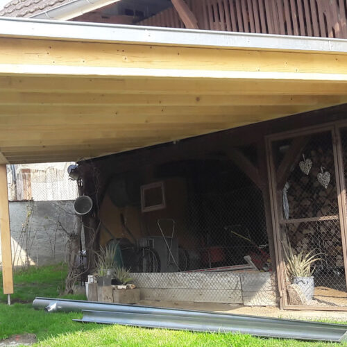 Carport triangulaire adossé à une grange du Sundgau