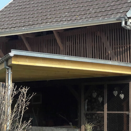 Carport triangulaire adossé à une grange du Sundgau