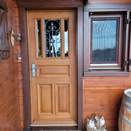 Porte extérieur bois massif avec panneaux et grille
