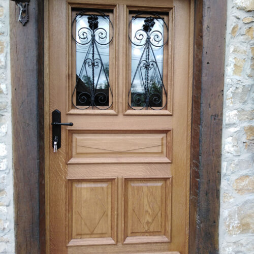 Porte extérieur bois massif avec panneaux et grille